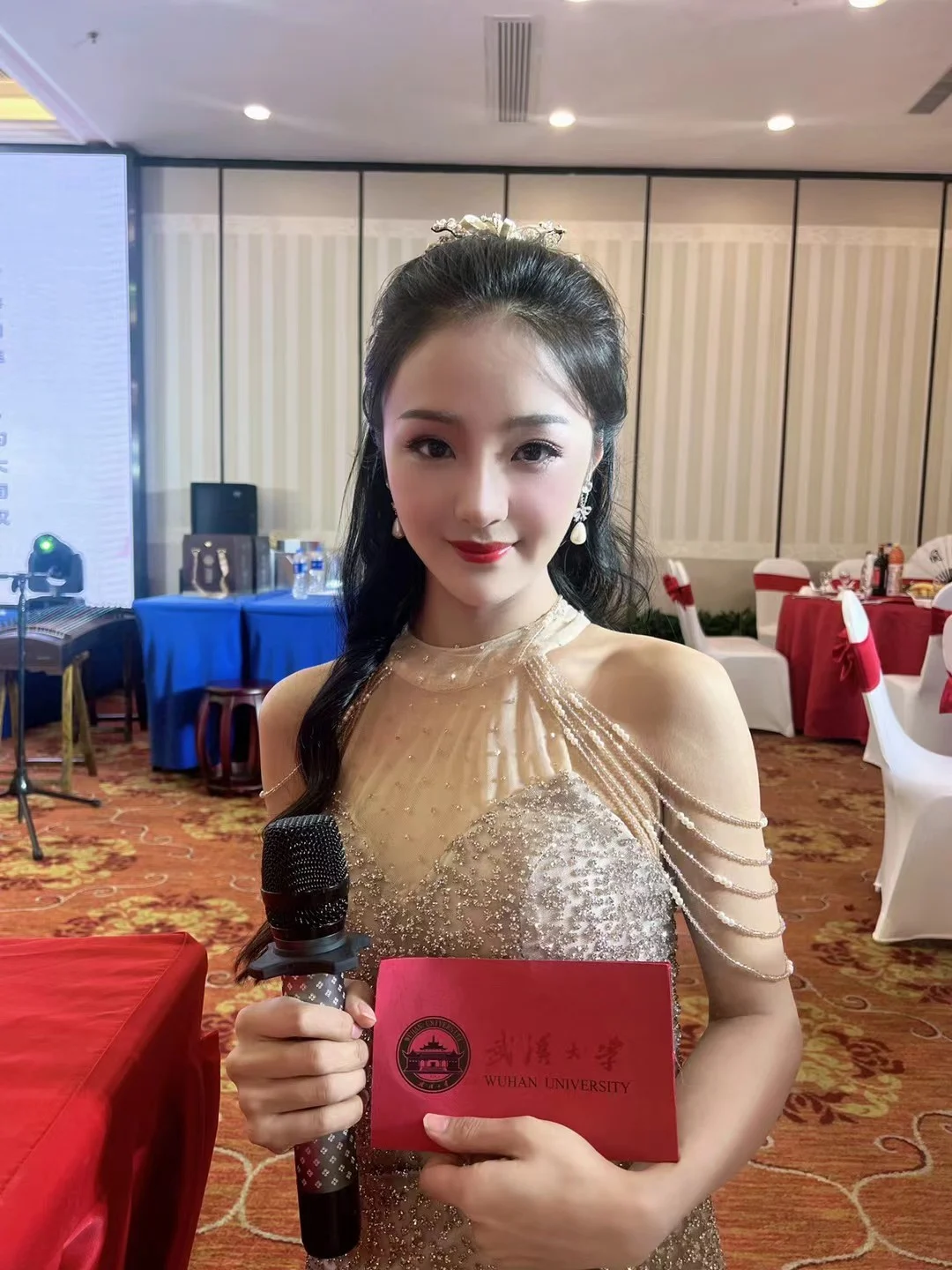 石小雨手持麦克风与武汉大学纪念卡，在活动现场